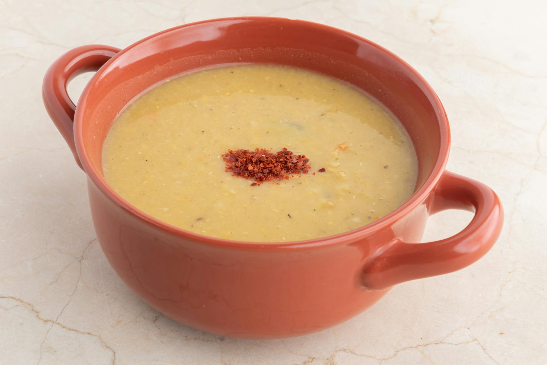 Domowa zupa z soczewicy w glinianej misce na stole